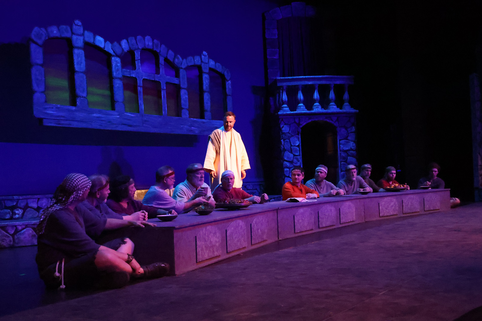 Jesus speaks to apostles gathered at a table.